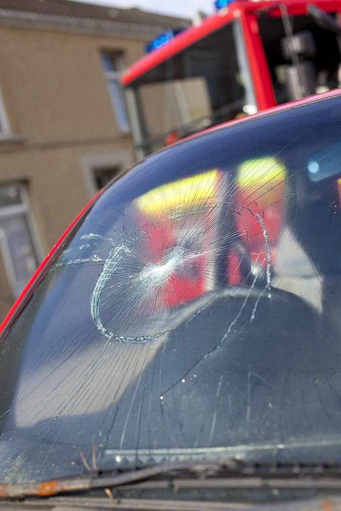 Impact sur le pare-brise d'un véhicule à l'arrêt